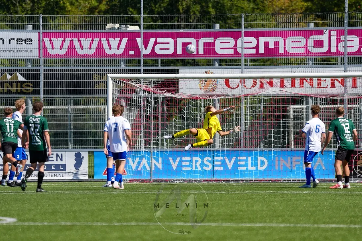 Daniël Beerdsen duikt naar een bal in de kruising, in het geel als keeper van SDV Barneveld
